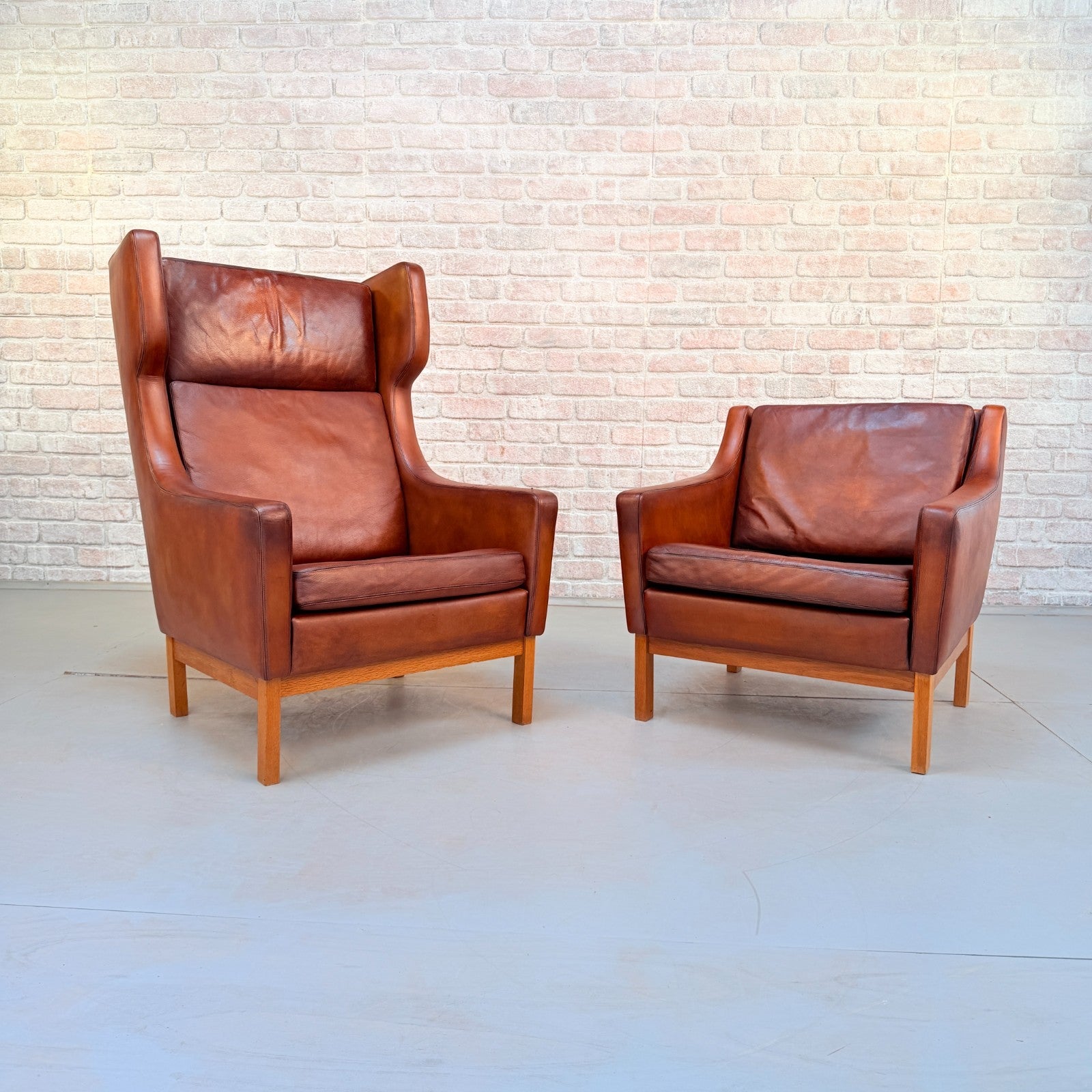 Vintage 1970s His & Hers Danish Tan Leather Armchairs Solid Oak Base Pair