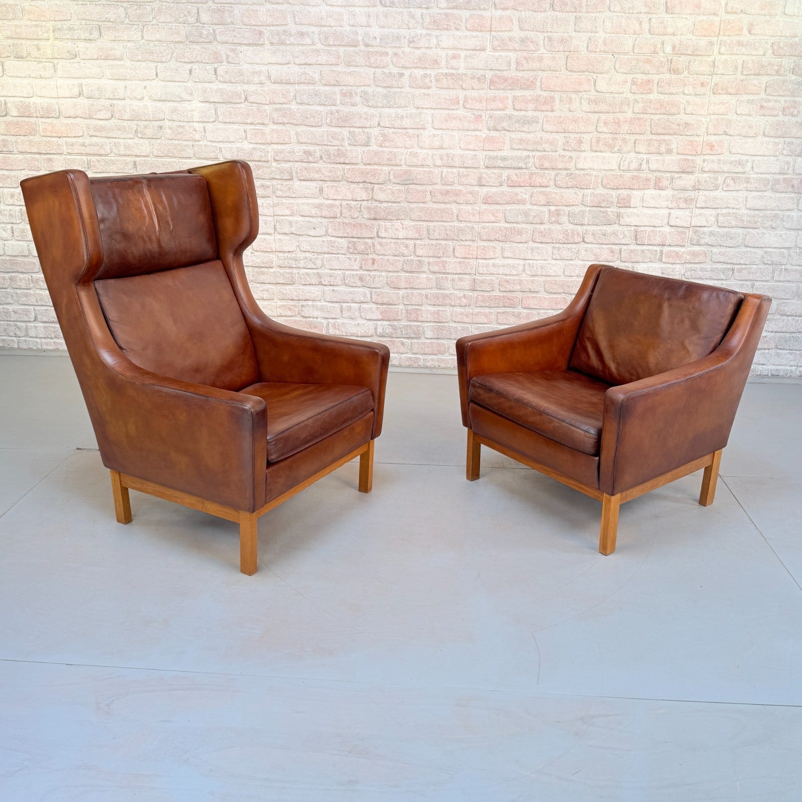 Vintage 1970s His & Hers Danish Tan Leather Armchairs Solid Oak Base Pair