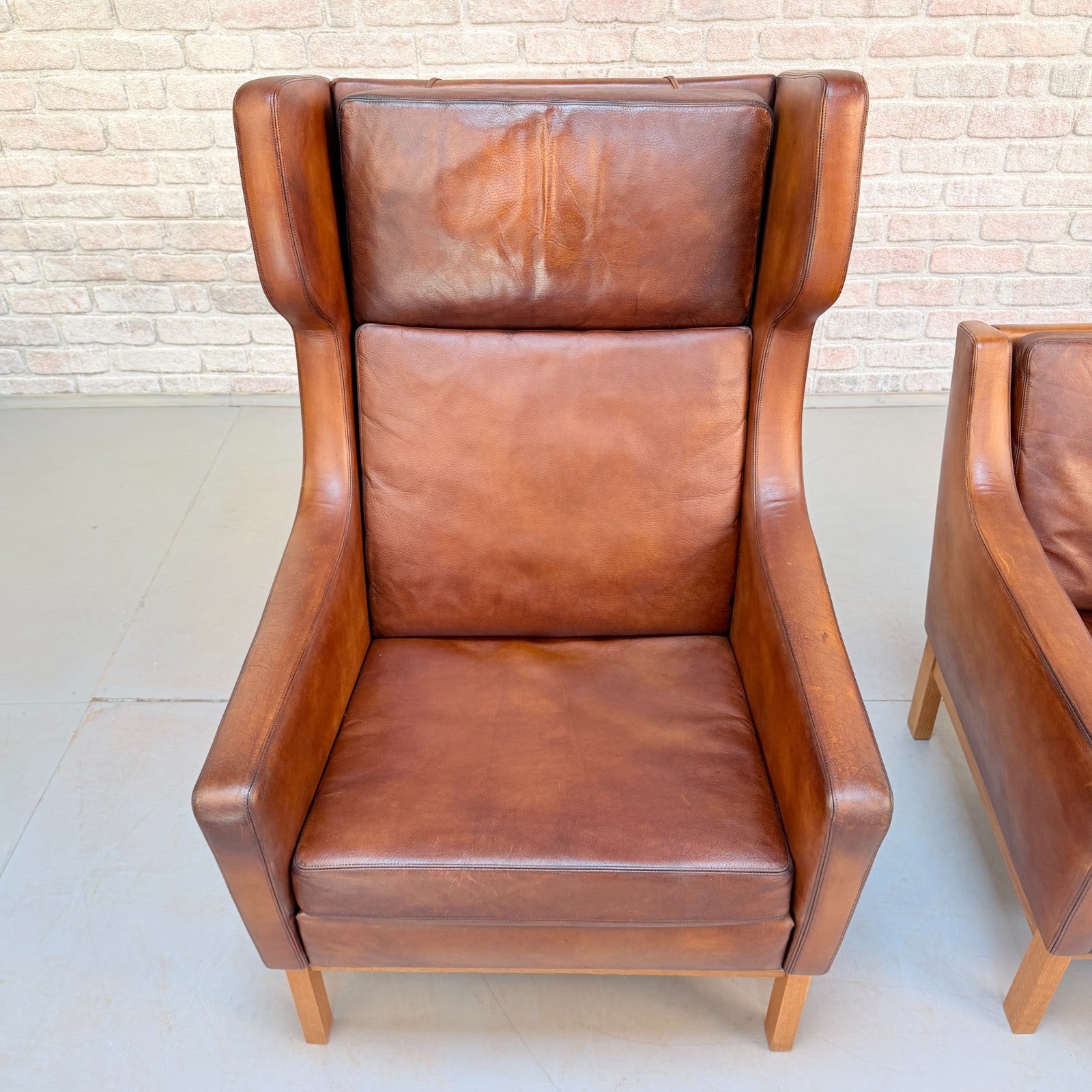 Vintage 1970s His & Hers Danish Tan Leather Armchairs Solid Oak Base Pair