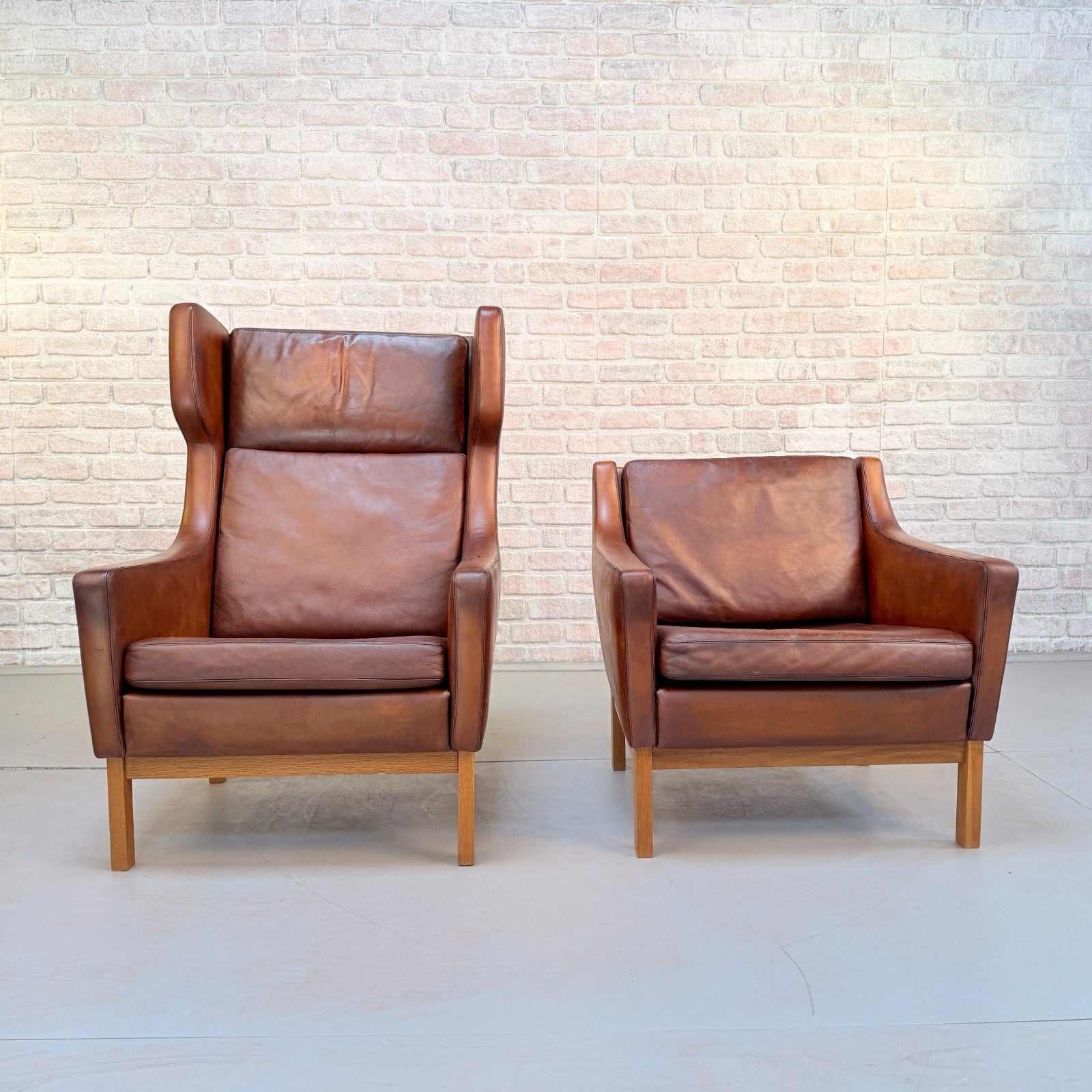Vintage 1970s His & Hers Danish Tan Leather Armchairs Solid Oak Base Pair