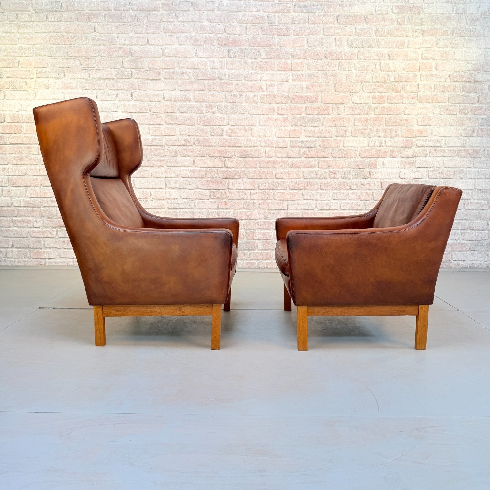 Vintage 1970s His & Hers Danish Tan Leather Armchairs Solid Oak Base Pair