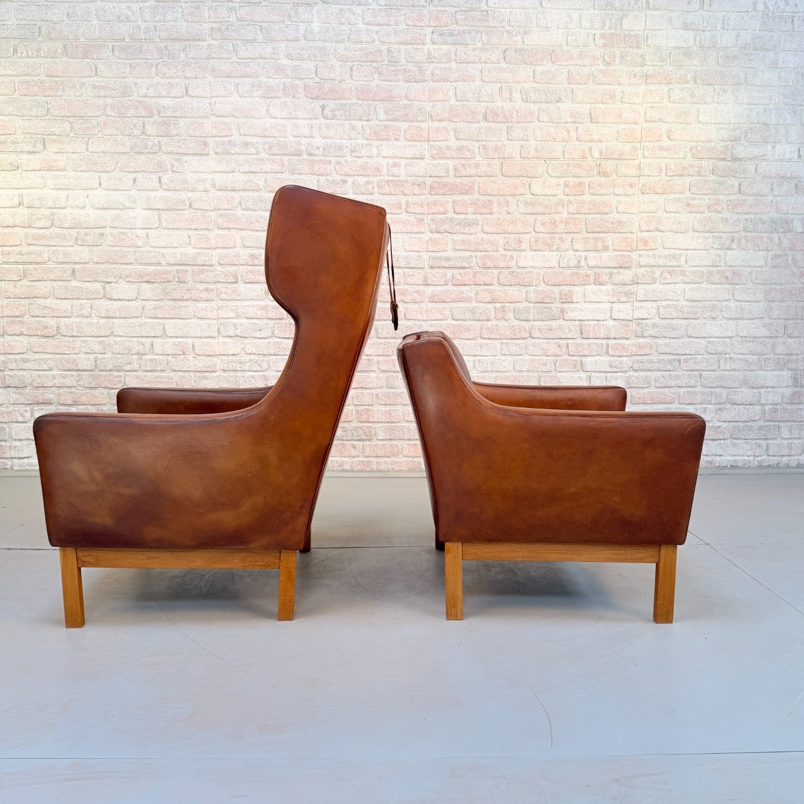 Vintage 1970s His & Hers Danish Tan Leather Armchairs Solid Oak Base Pair