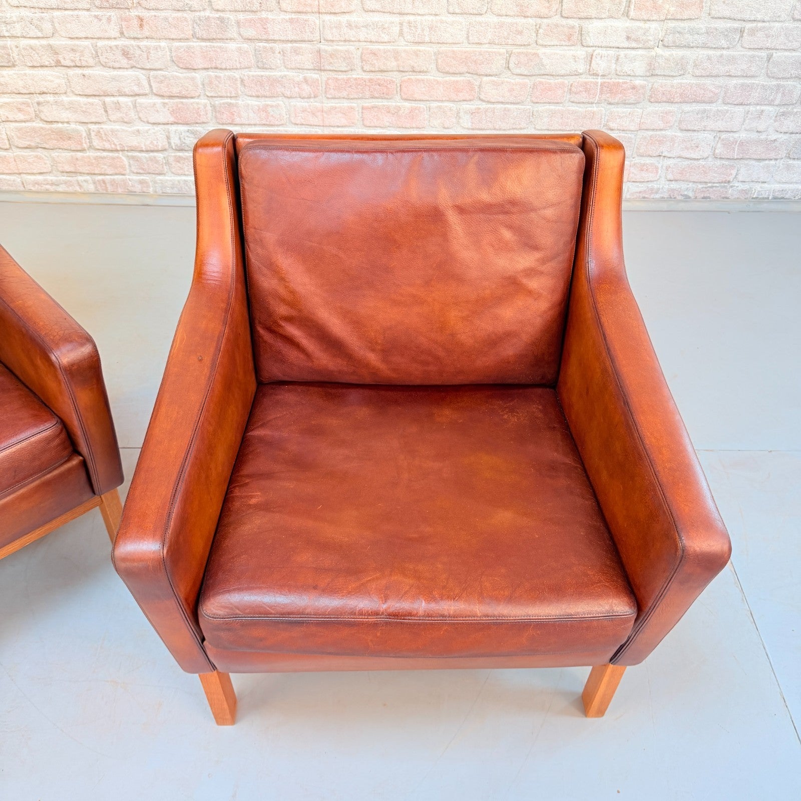 Vintage 1970s His & Hers Danish Tan Leather Armchairs Solid Oak Base Pair
