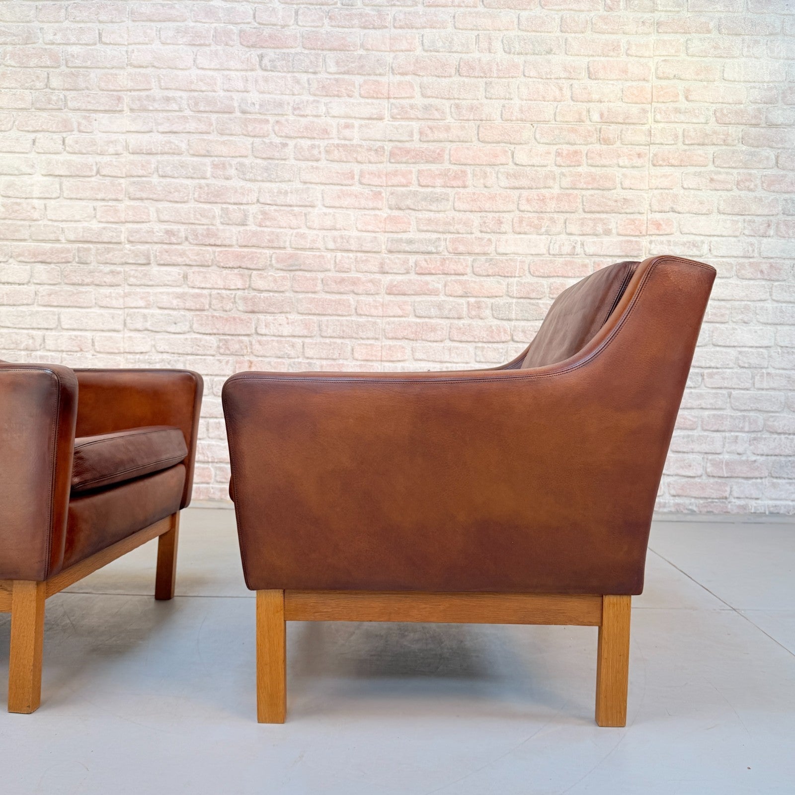 Vintage 1970s His & Hers Danish Tan Leather Armchairs Solid Oak Base Pair