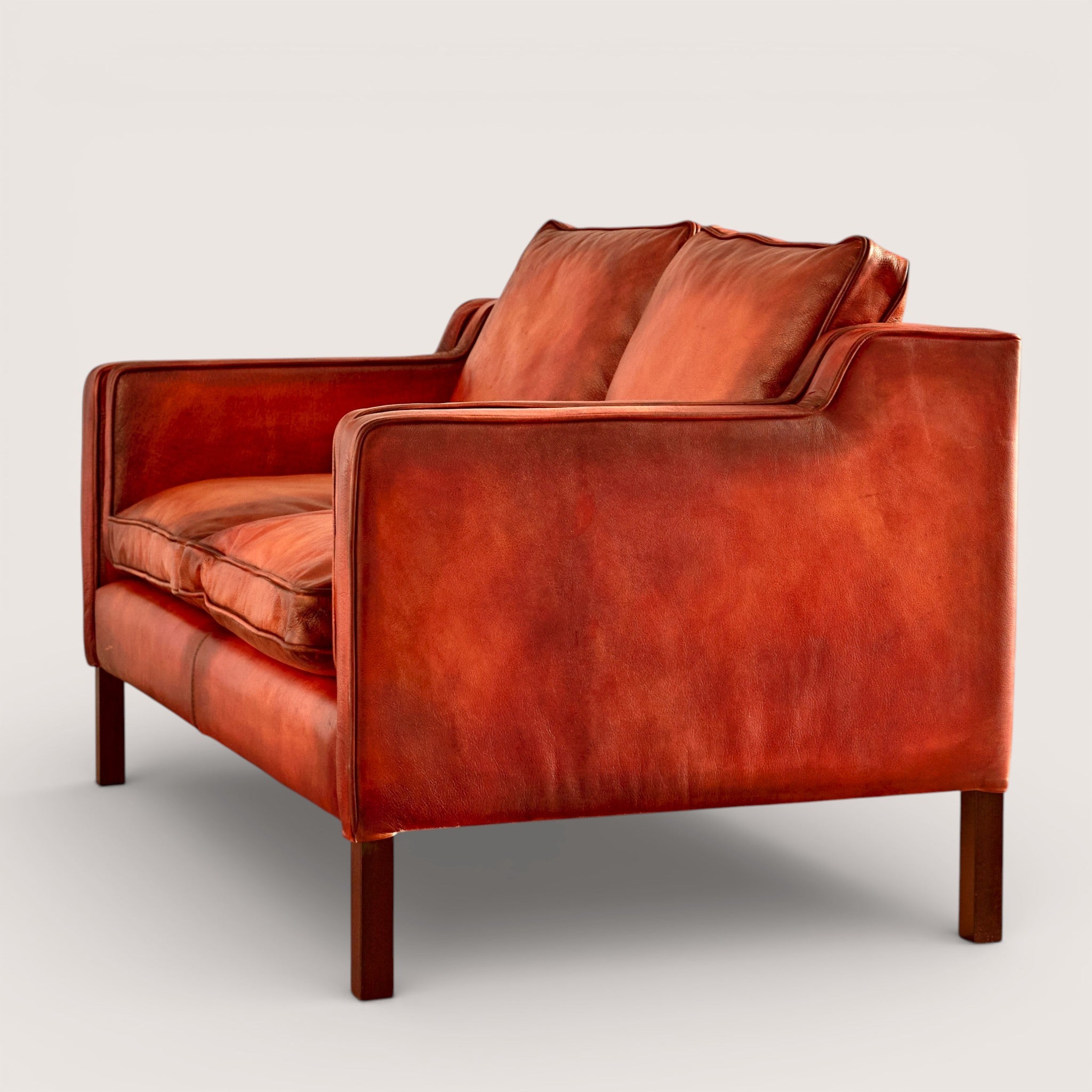 luxury-hand-dyed-mid-century-leather-two-seater-sofa-white-background-side