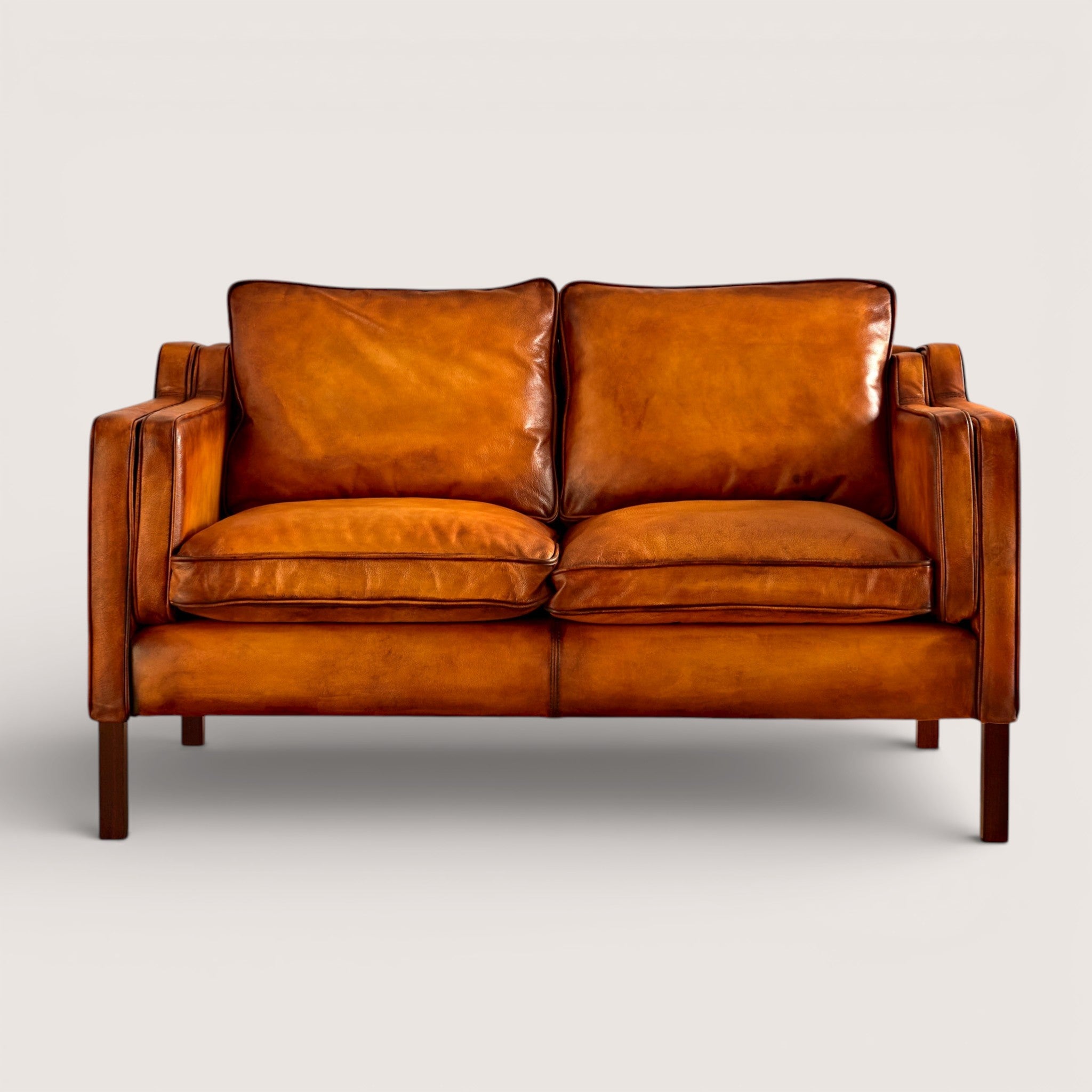 luxury-hand-dyed-mid-century-tan-leather-two-seater-sofa-white-background-front