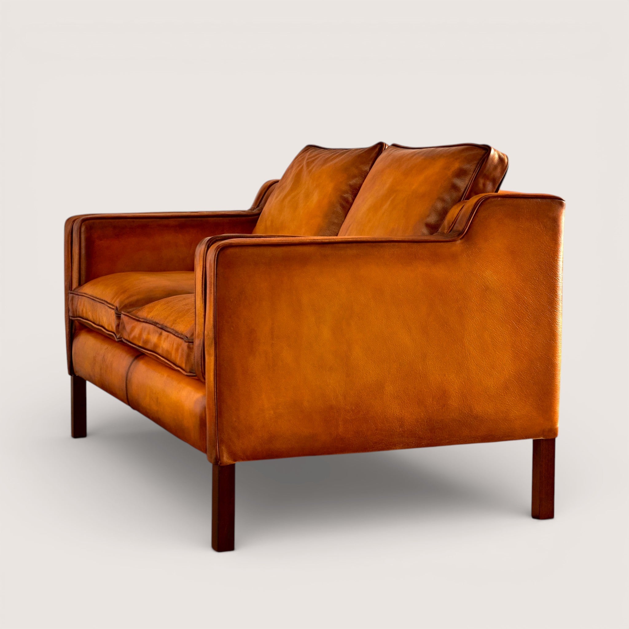 luxury-hand-dyed-mid-century-tan-leather-two-seater-sofa-white-background-side